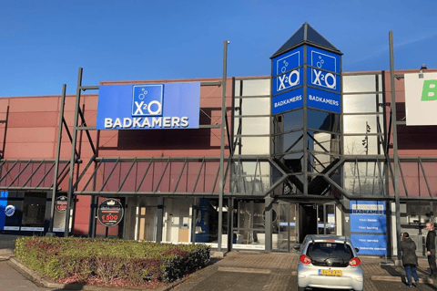 X²O Badkamers winkel met opvallende toreningang en gevel in een retailomgeving – X²O badkamers
