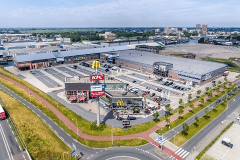 Luchtbeeld van een modern retailpark met diverse winkels en horecagelegenheden zoals KFC en McDonald’s, ruime parkeermogelijkheden en een uitstekende ligging langs belangrijke verkeersassen – X²O badkamers