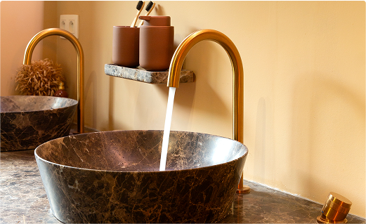 Vasques en marbre avec robinet doré dans un style hôtel chic – disponibles chez X²O Salles de bains.