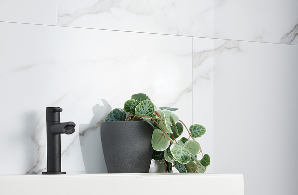Lavabo dans une salle de bains de x²o salles de bains avec panneaux muraux Dumawall effet marbre blanc, robinet noir et plante décorative pour une ambiance élégante.