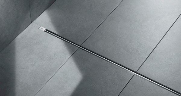 Detailaufnahme eines modernen Duschbodens mit grauen Fliesen und einem minimalistischen, integrierten Abfluss
