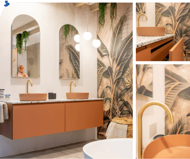 Salle de bains moderne avec double lavabo, robinets dorés, plan terrazzo, tapisserie tropicale et miroirs.