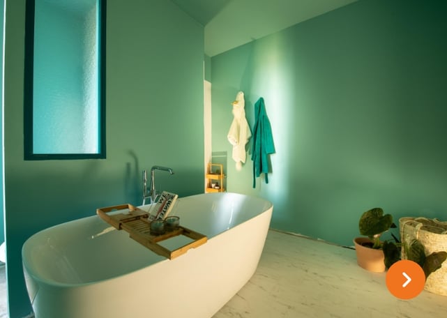 Minimalistische badkamer met turquoise muren, vrijstaand bad en houten badrekje