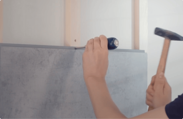 Pose d'un panneau mural Dumawall dans une salle de bains de x²o salles de bains, fixé facilement contre le mur.