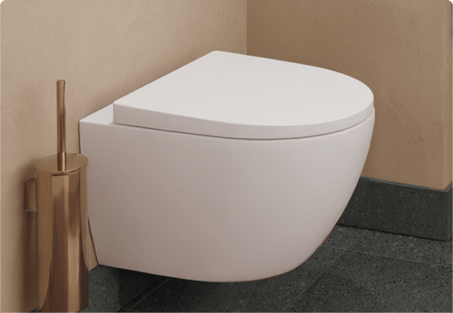 Une toilette suspendue blanche avec couvercle brillant dans une salle de bain aux tons cuivrés. Brosse WC dorée assortie, élégance par x²o badkamers.