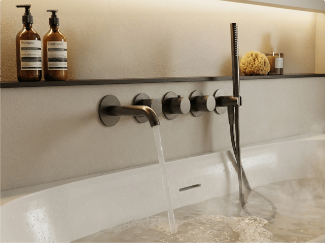 Robinetterie de baignoire murale noire avec bec incurvé laissant couler l’eau, quatre commandes rondes et douchette noire à côté du bain, dans une salle de bains de x²o salles de bains.