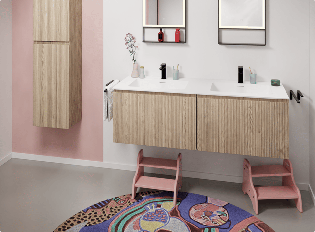 Salle de bains familiale rose et blanche avec meubles en bois clair. Une version ludique des couleurs tendance 2026 chez X²O Salle de bains.