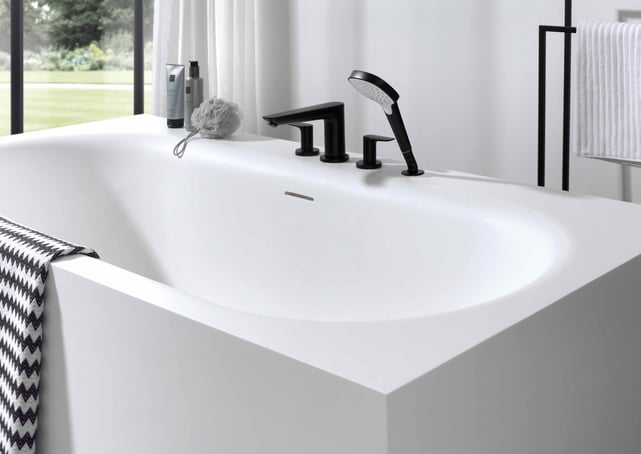 Modern wit bad met matzwarte kranen en handdouche in een minimalistische badkamer.