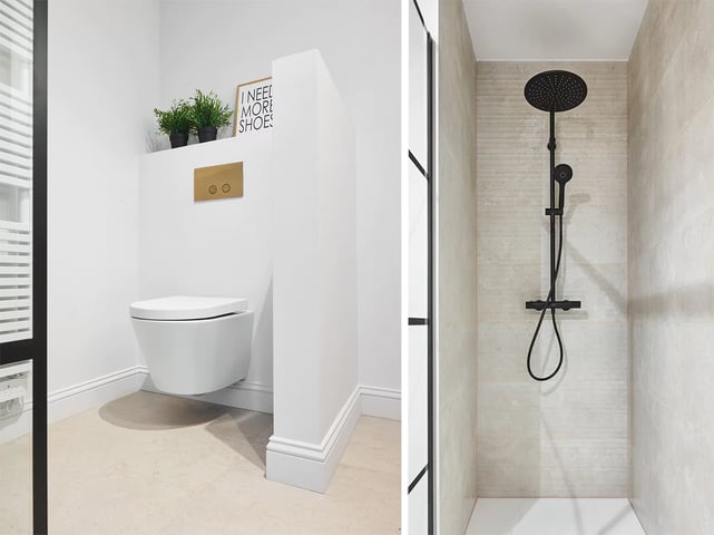 Witte wandcloset met zwarte knop en planten, naast een douche met zwarte regendouchekop.