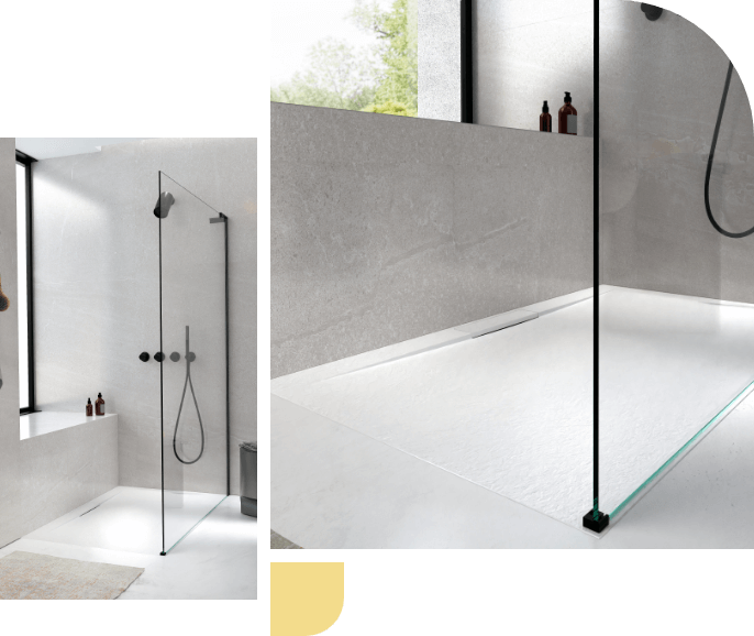 Moderne begehbare Dusche mit Glaswand, schwarzem Metall-Duschkopf und minimalistischem Design.