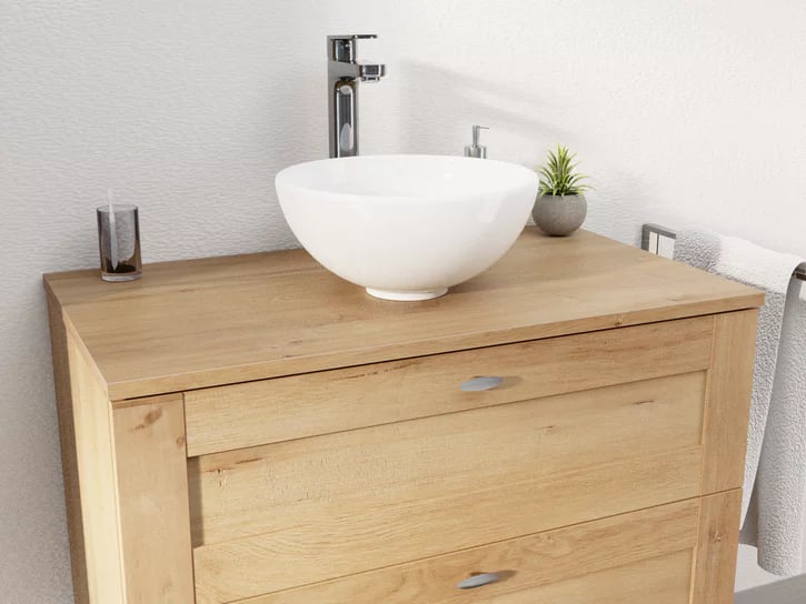 Detail van een houten badkamermeubel van x²o badkamers met ronde witte opzetwastafel, chromen kraan en minimalistische accessoires op het werkblad.