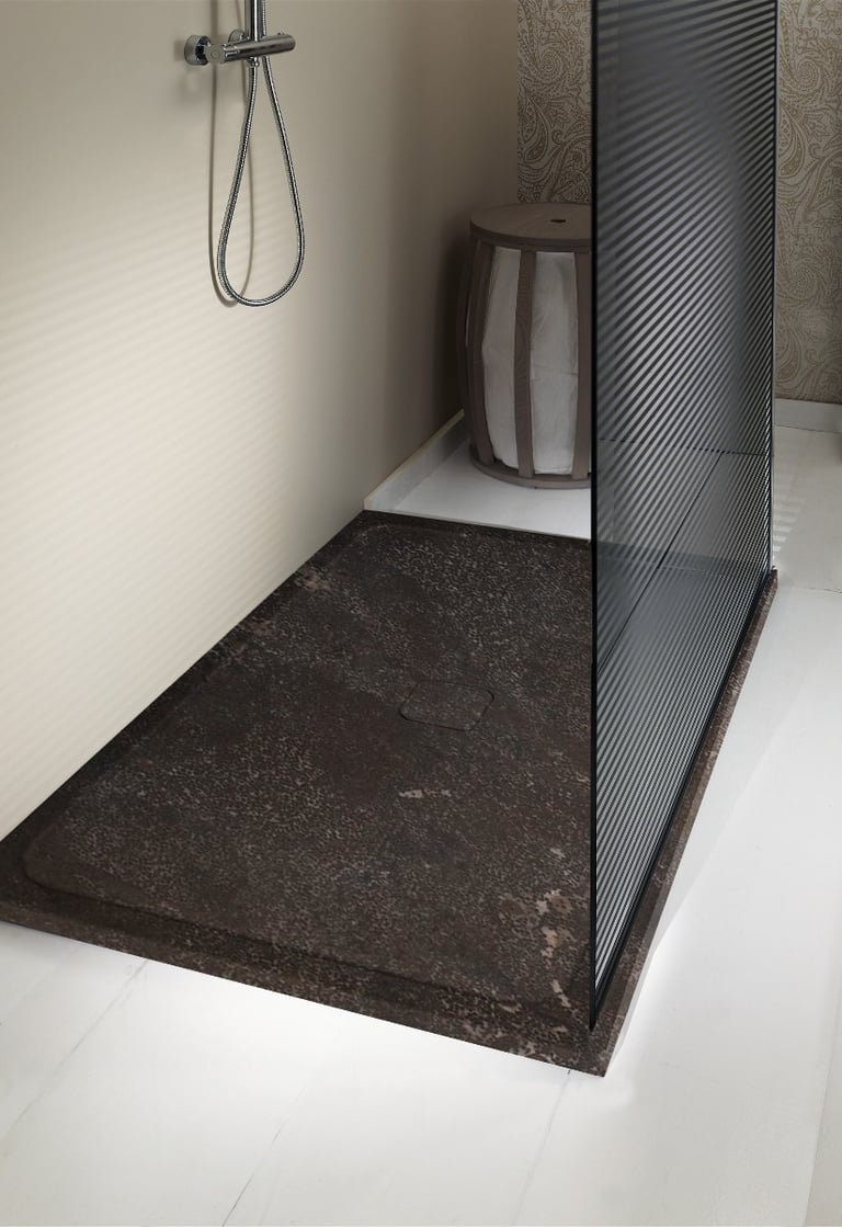 Moderne Dusche mit einem dunkelbraunen Steinboden und einer Glaswand. Es gibt einen versteckten Abfluss und einen grauweißen Stuhl
