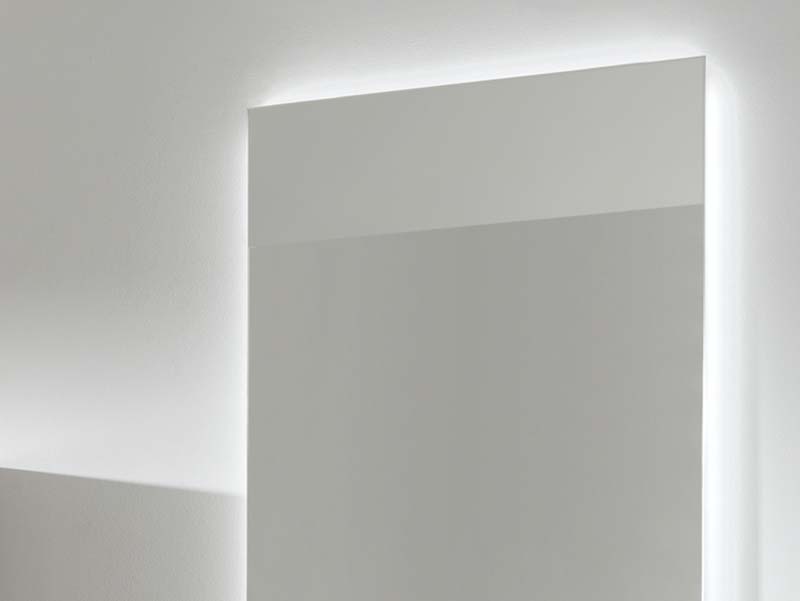 Detail van een rechthoekige spiegel met ingebouwde, subtiele LED-achtergrondverlichting.