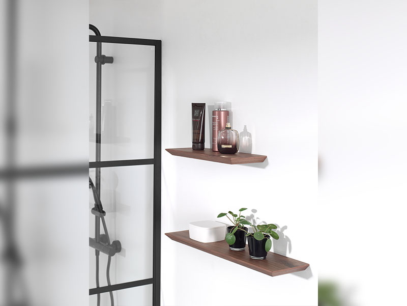 Houten wandplanken in de badkamer voor decoratie en opslag, minimalistisch ontwerp naast de douche.