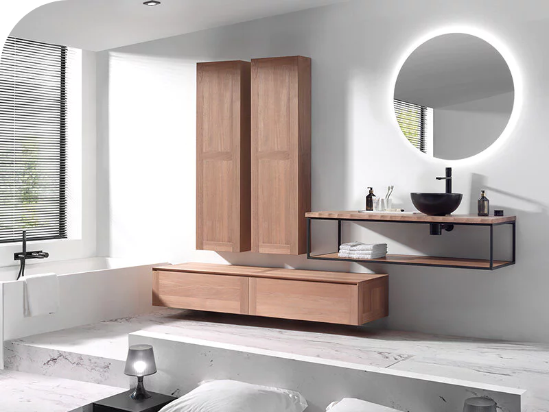 Modern badkamermeubel in hout met zwarte opzetwaskom, metalen frame en ronde spiegel met LED-verlichting.
