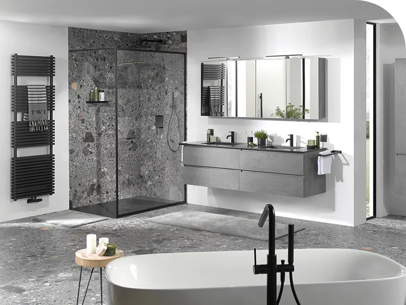 Salle de bain luxueuse avec douche à l’italienne, baignoire îlot et meuble suspendu aspect béton.