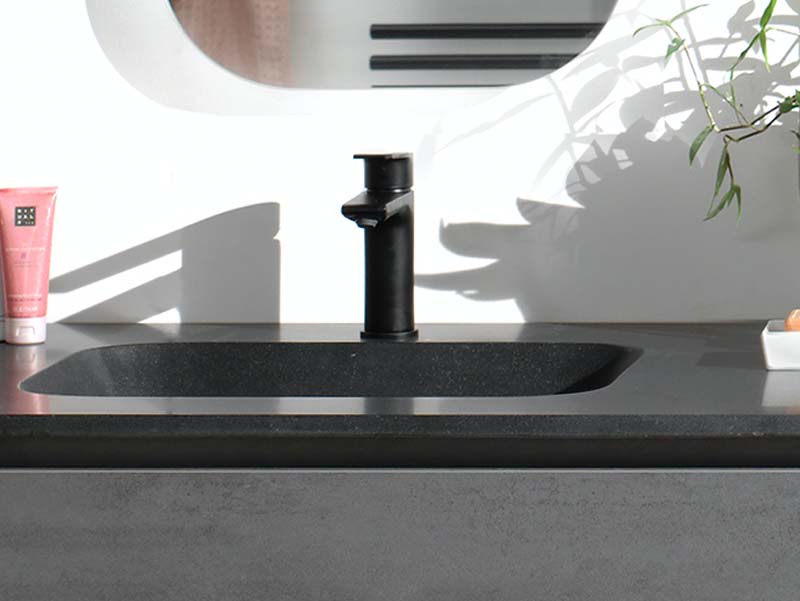 Lavabo encastré noir avec robinet noir mat sur un plan foncé, design moderne et élégant.