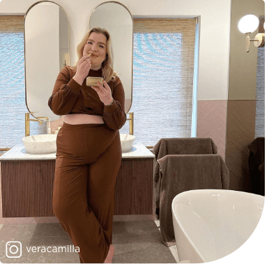 Salle de bains luxueuse avec meuble double vasque, miroirs ovales et tons bois pour une ambiance élégante.