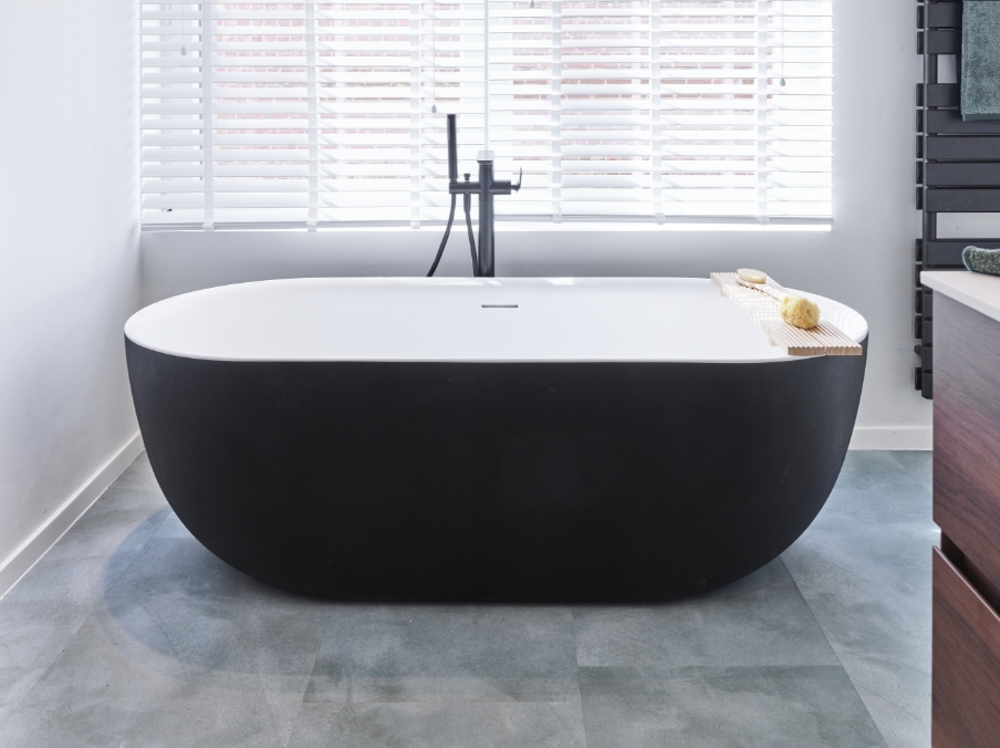 Détail d’un robinet noir de salle de bains de x²o salles de bains au-dessus d’une vasque blanche, avec design épuré, forme minimaliste et style scandinave.