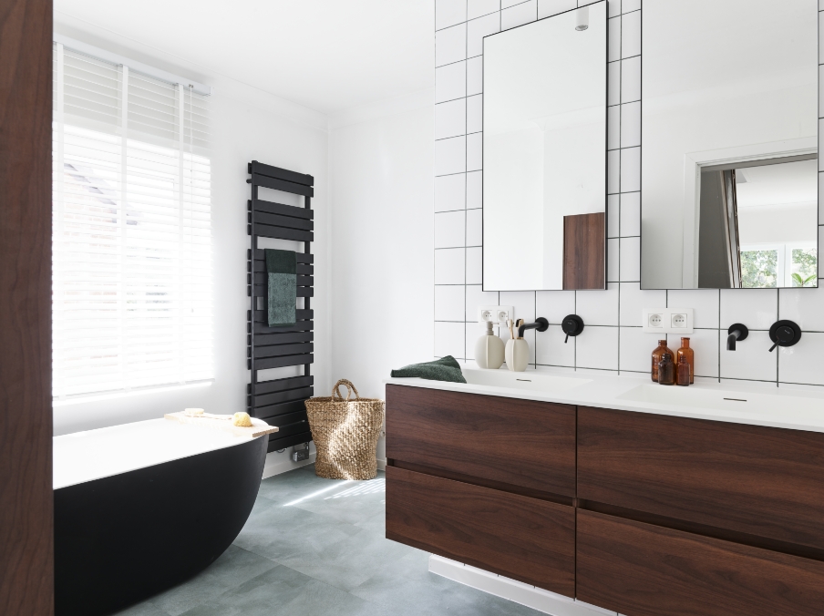 Vue d’ensemble d’une salle de bains scandinave de x²o salles de bains avec meubles en bois, accents noirs, carrelage blanc, radiateur porte-serviettes et ambiance harmonieuse.