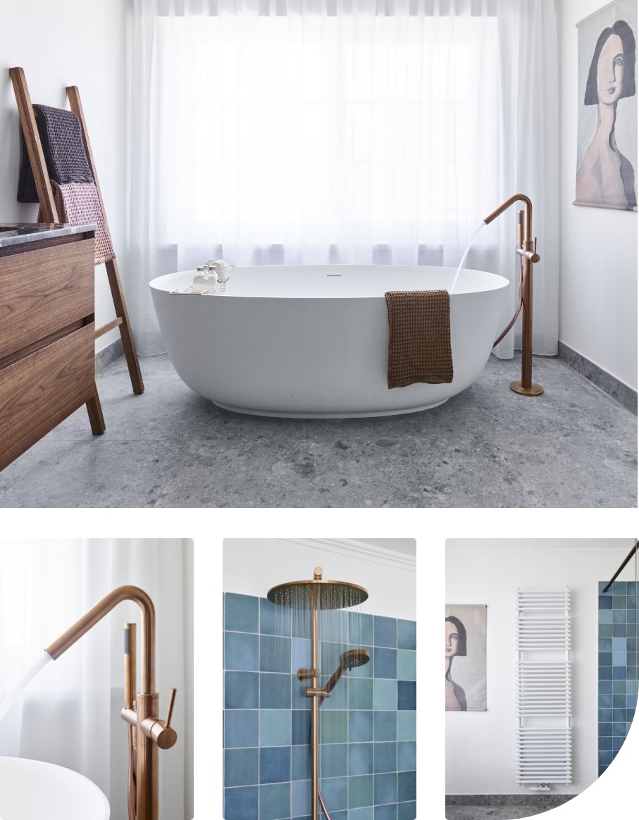 Salle de bains avec une baignoire îlot, un robinet doré, une douche avec des carreaux bleus, un porte-serviettes et une peinture au mur