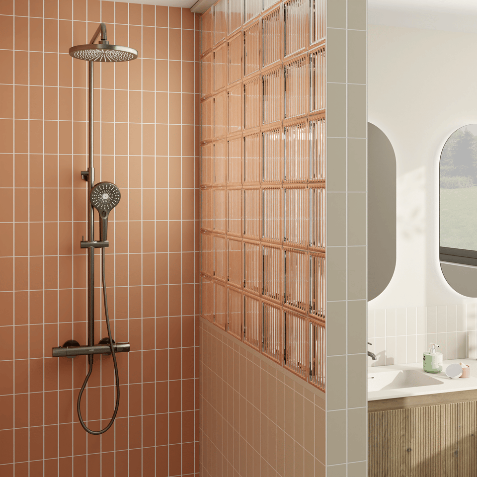 Begehbare Dusche mit orangefarbenen Wandfliesen, schwarzer Regendusche und Glasbausteinwand neben dem Waschtisch bei x²o Badezimmer