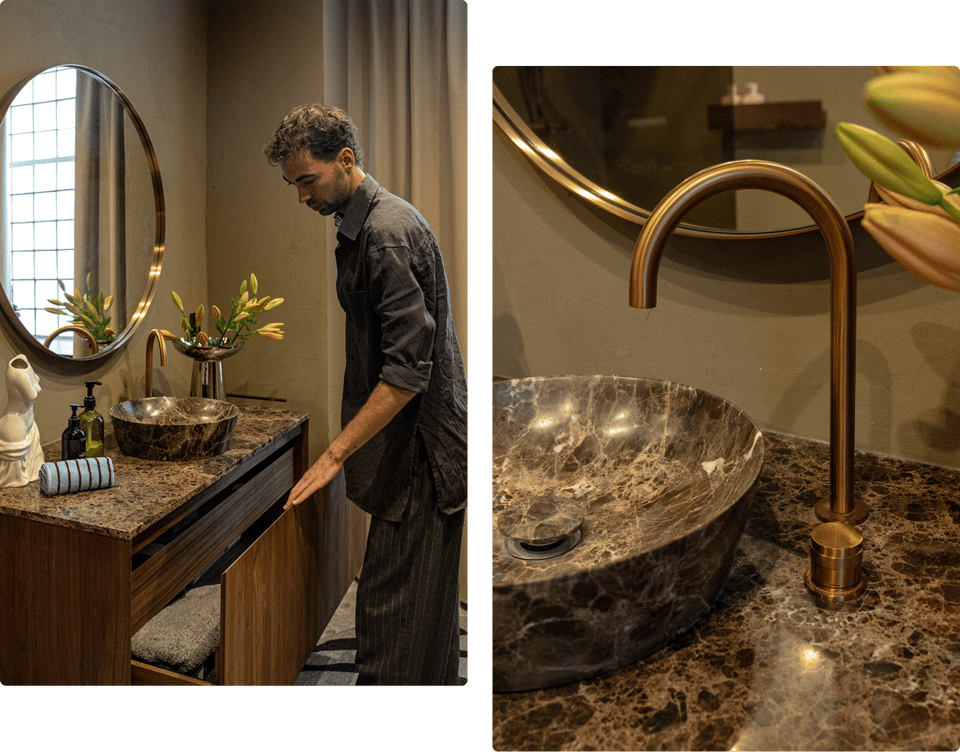 Daan Alferink opent een houten lade van het X²O Badkamers meubel met marmeren blad. Detail van een X²O kraan in geborsteld goud boven een marmeren kom.