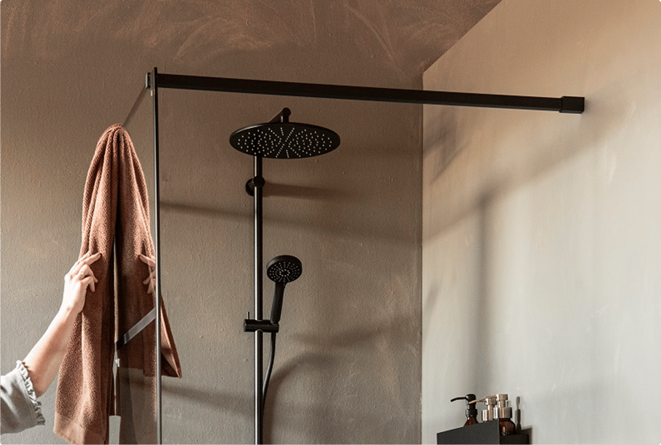 Douche à l’italienne noire avec douche pluie et douchette noires mates, structure métallique noire et paroi en verre dans une salle de bains au style industriel de x²o salles de bains.