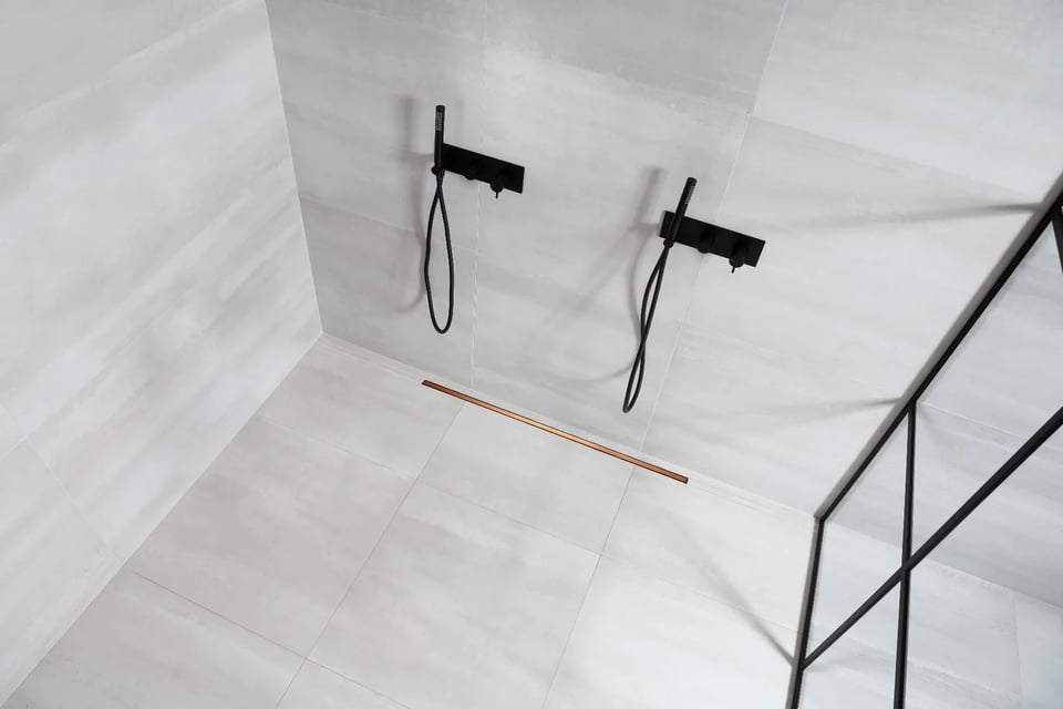 Een moderne dubbele douche met zwarte kranen en een minimalistisch ontwerp in een marmeren ruimte.